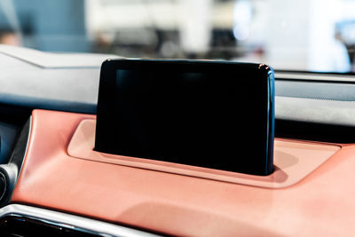 Close-up of mobile phone on dashboard of car