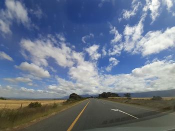 Empty road against cloudy sky