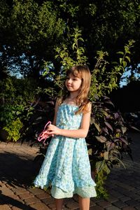 Full length of girl standing against tree