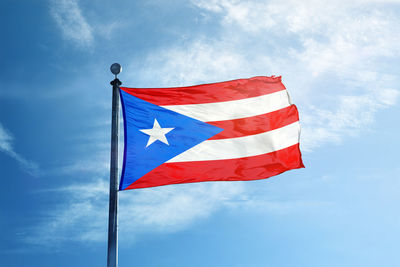 Low angle view of flag against blue sky