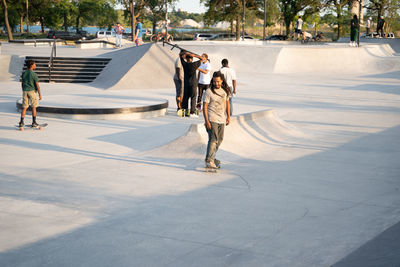 Rear view of people walking on footpath in city