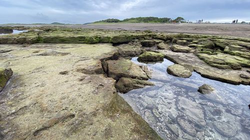 Rocks on shore against sky