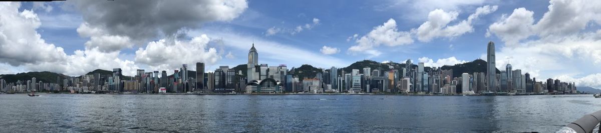 Buildings by river against sky