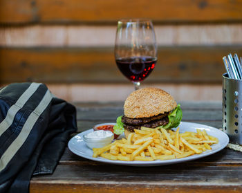 Hamburger with fries and a glass of wine