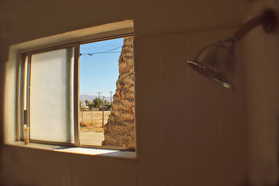 Clothes hanging on window against sky