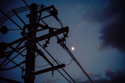 Low angle view of silhouette crane against sky at sunset