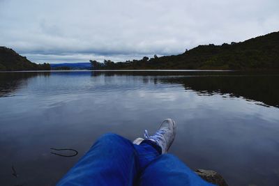 Low section of man relaxing in lake