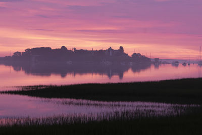 Dawn light glows a vibrant pink over biddeford pool on maine coast.