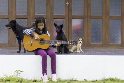 Full length of woman playing guitar