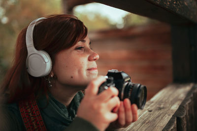 Portrait of young woman photographing with camera