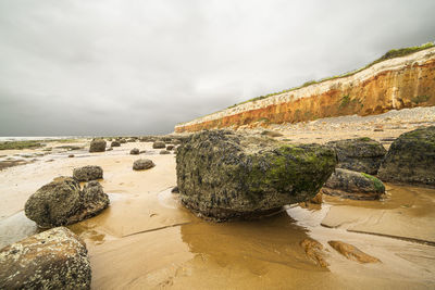 Panoramic view of rocks on beach against sky