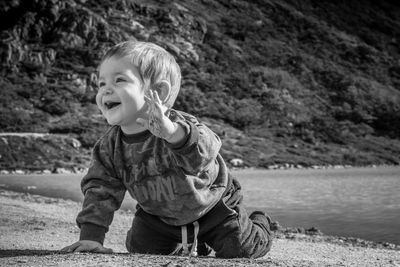 Boy sitting on shore