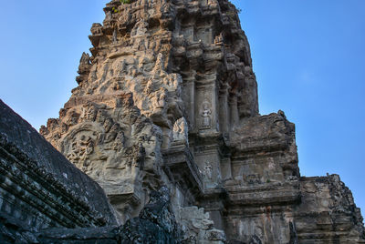 Low angle view of sculpture on building against sky