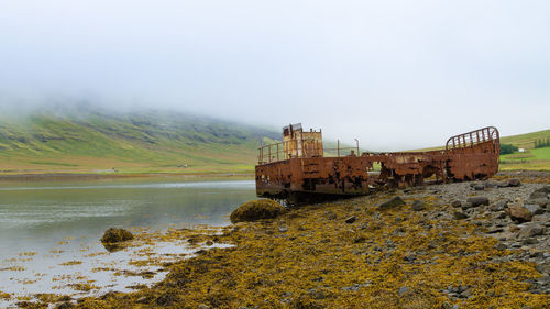 Abandoned ship on land against sky