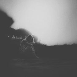 Rear view of woman standing on field against sky