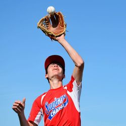 Low angle view of man playing baseball against blue sky