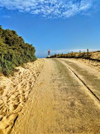 Man walking on road against sky