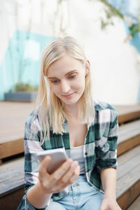 Smiling young woman using mobile phone