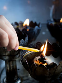 Midsection of person holding burning candles