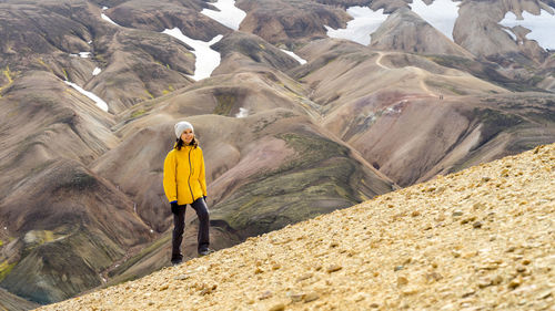 Young woman hiker walking around icelandic highlands and mossy hills