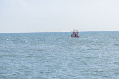 Sailboat sailing on sea against clear sky