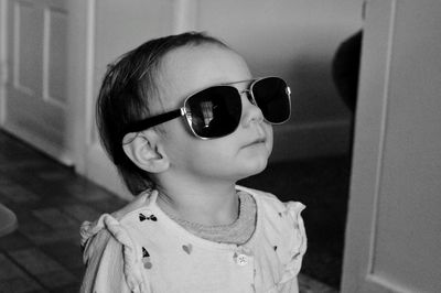 Baby girl wearing sunglasses at home