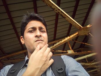 Low angle view of young man under shed