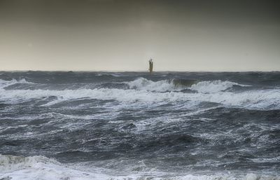 Lighthouse by sea against sky