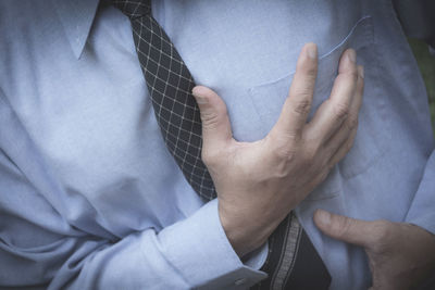 Midsection of businessman suffering from chest pain