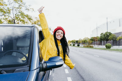 Portrait of smiling young woman on car