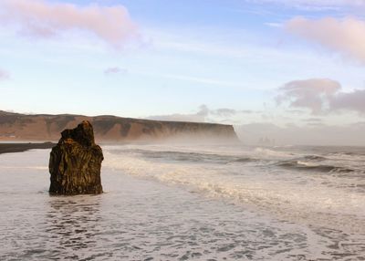 Rock formation in sea against sky