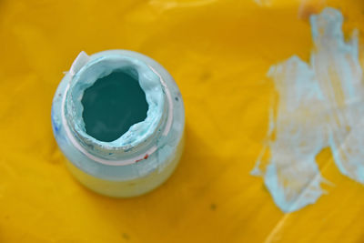 Directly above shot of blue paint bottles on paper