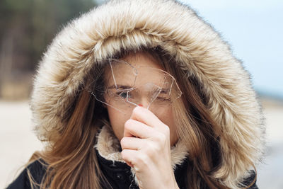 Young woman holding a piece of ice in front of her face