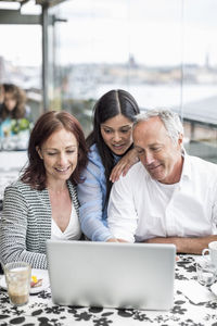 Business colleagues using laptop at restaurant