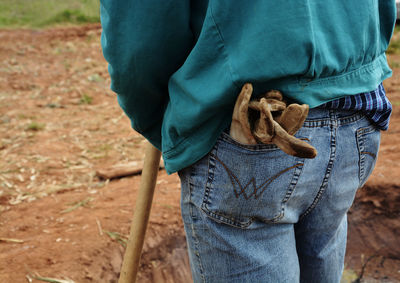 Midsection of farmer standing on farm field