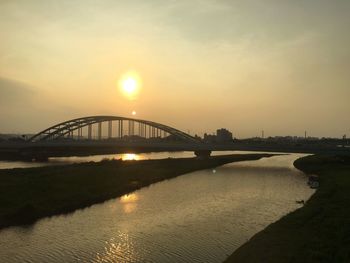 Bridge over river at sunset