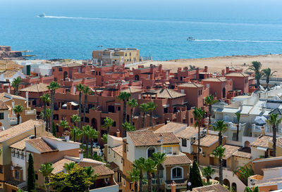 High angle view of buildings in city by sea