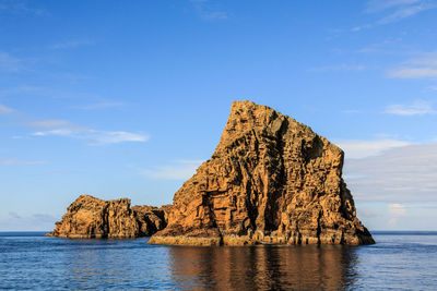 Scenic view of rock formation in sea against sky