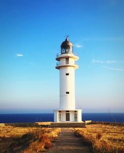 Lighthouse by sea against sky