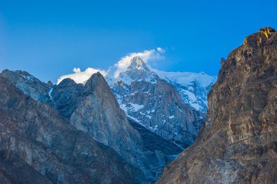 Scenic view of mountains against blue sky