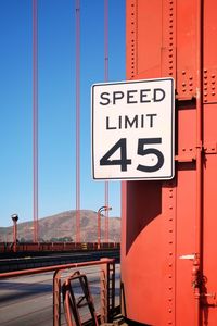 Road sign against clear blue sky