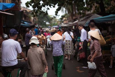 Rear view of people walking on street market