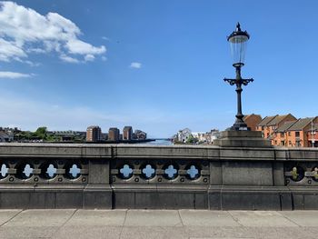 People walking on street against blue sky