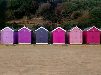 Pink and purple wooden cabins on the edge of bournemouth beach, south england
