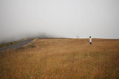 Man standing on field against sky