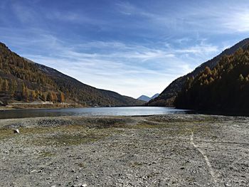 Scenic view of lake by mountains against sky