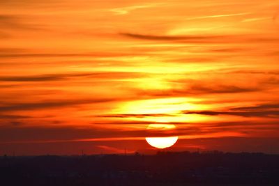 Scenic view of silhouette landscape against orange sky