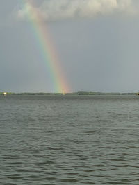 Scenic view of rainbow over sea against sky