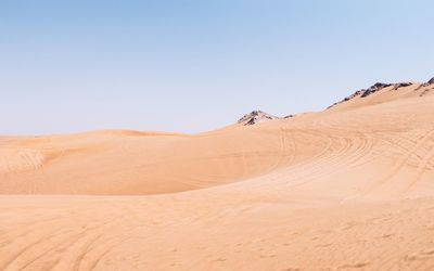 Scenic view of desert against clear blue sky