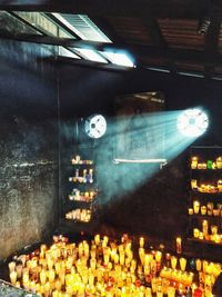 Illuminated lights hanging from ceiling in city at night